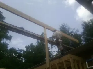 Carpenter setting a ridge beam over a new addition frame — Ice Dam Removal by Roofing Brothers in Picture Rocks