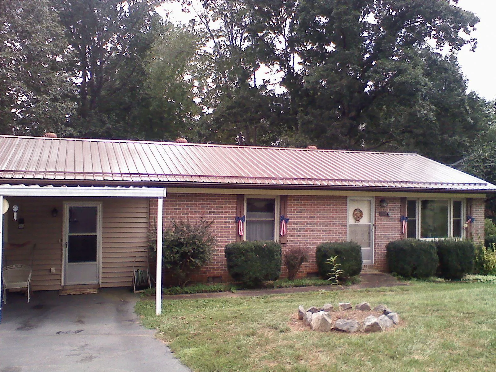Bronze metal roof and carport on a brick ranch home — Roof Repair work by our crew in Picture Rocks
